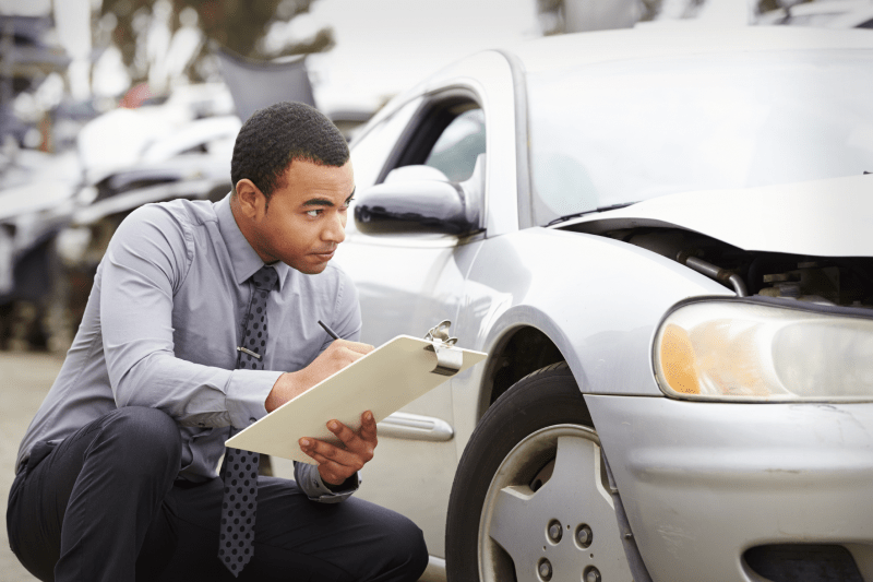 Insurance Agent Inspecting Car